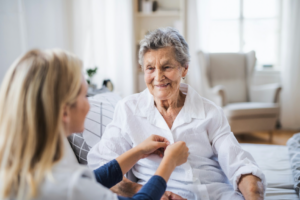 Caregiver assisting elderly woman at home, illustrating IHSS personal care services in Colorado